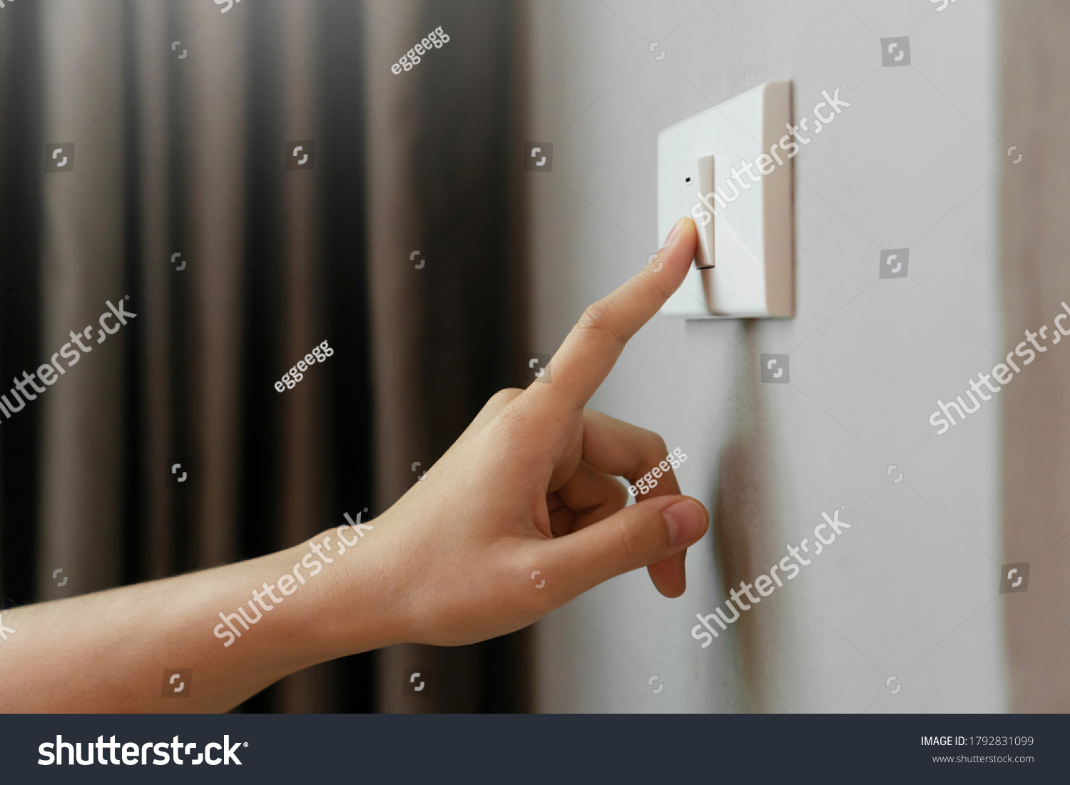 Person switching off a light to save electricity